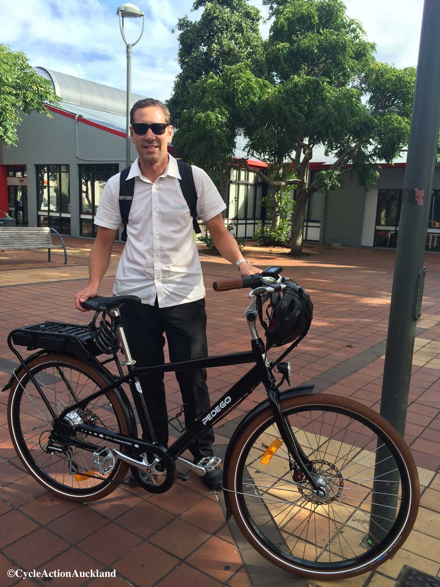 Man in white collared shirt holding a Pedego City Commuter black edition