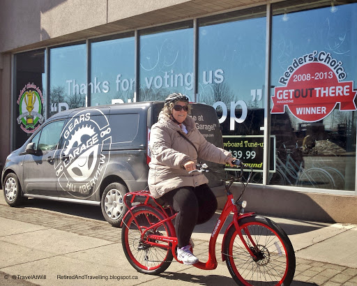 Woman riding a red Pedego Boomerang wearing winter jacket and helmet