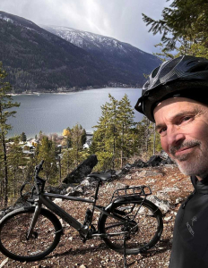 Man with Avenue Pedego Ebike on trail in the mountains with lake