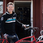 Owner stands with ebike next to Pedego store.