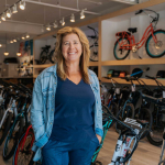 Pedego Canmore owner Amy McCaig stands inside her store in front of ebikes.