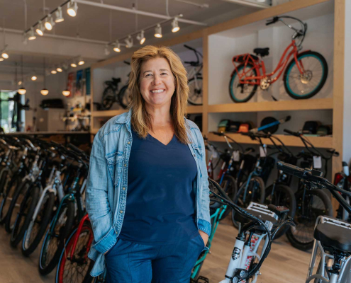 Pedego Canmore owner Amy McCaig stands inside her store in front of ebikes.