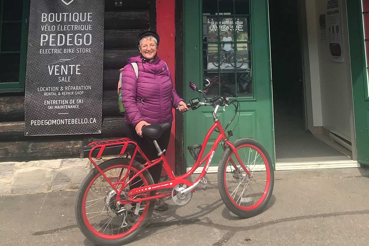 Woman wearing helmet with red Pedego Boomerang ebike