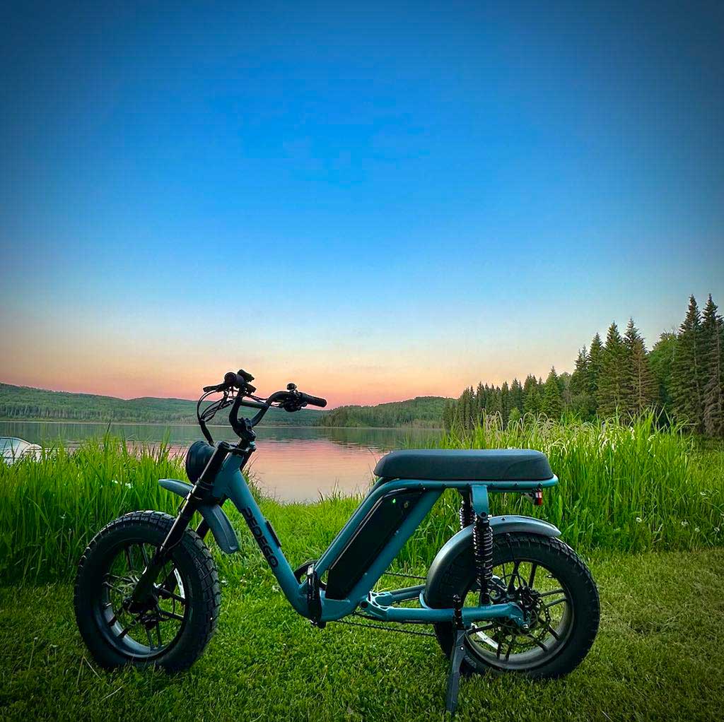 Pedego Moto parked alongside an Alberta lake with big sky.